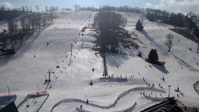 Aerial view of a snow-covered ski slope with lifts and skiers