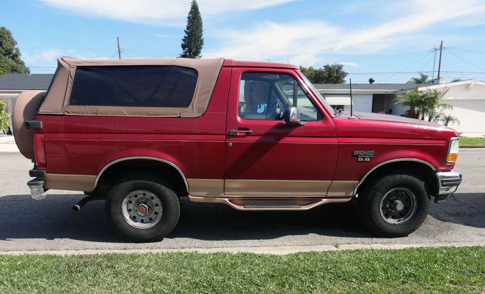 Red 1994 Ford Bronco Eddie Bauer, driver's side profile, tan soft top and trim