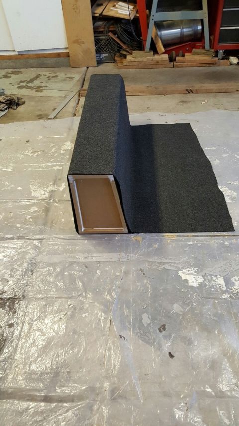 1996 Ford Bronco - A dark grey textured material is being applied to a brown rectangular object that is part of a larger, L-shaped structure. The structure is…