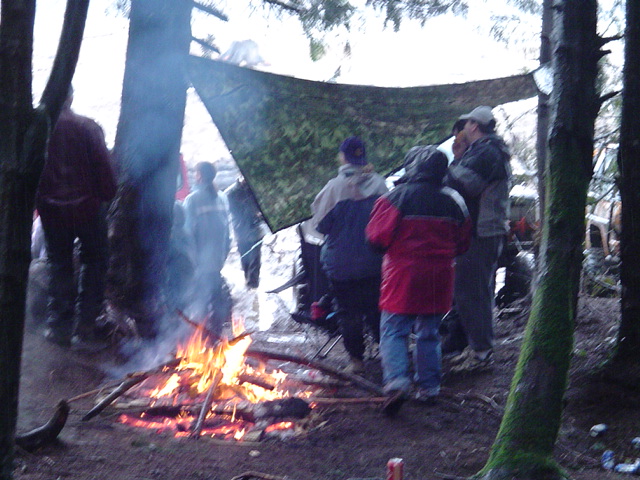 People around a campfire in a wooded area