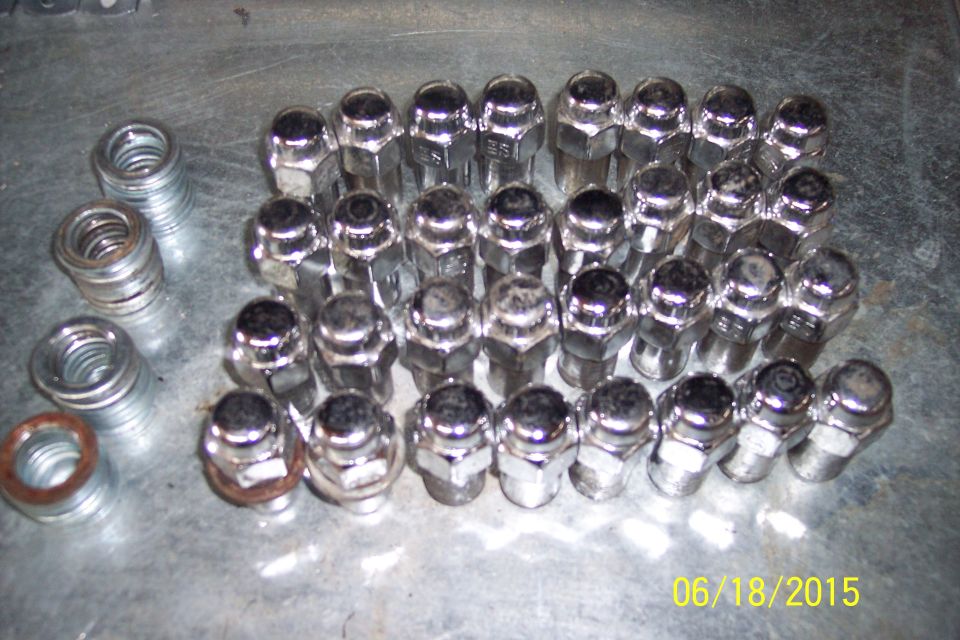 Lug nuts and washers on a metallic surface.