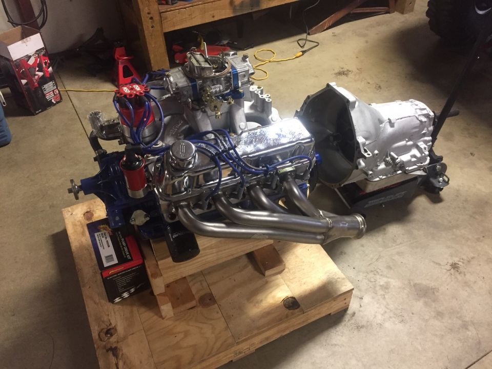 V8 engine and transmission assembly on a wooden pallet.
