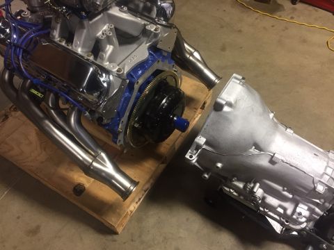 1982 Ford Bronco - A V8 engine with chrome valve covers and blue spark plug wires is connected to a silver automatic transmission. The engine and transmission…