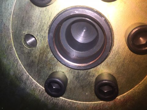 1982 Ford Bronco - A close-up view shows the hub of a vehicle, featuring several hex bolts and a central opening with machined inner surfaces. A threaded hole…