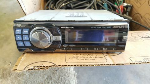 1996 Ford Bronco - A close-up view of an Alpine CDA-9886 CD receiver with a large rotary dial and various buttons. The receiver is placed on a cardboard box w…