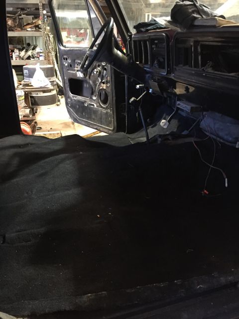 1979 Ford Bronco - The interior of a classic truck, possibly a Ford Bronco, is shown with the driver's door open. The dashboard and steering column are visibl…