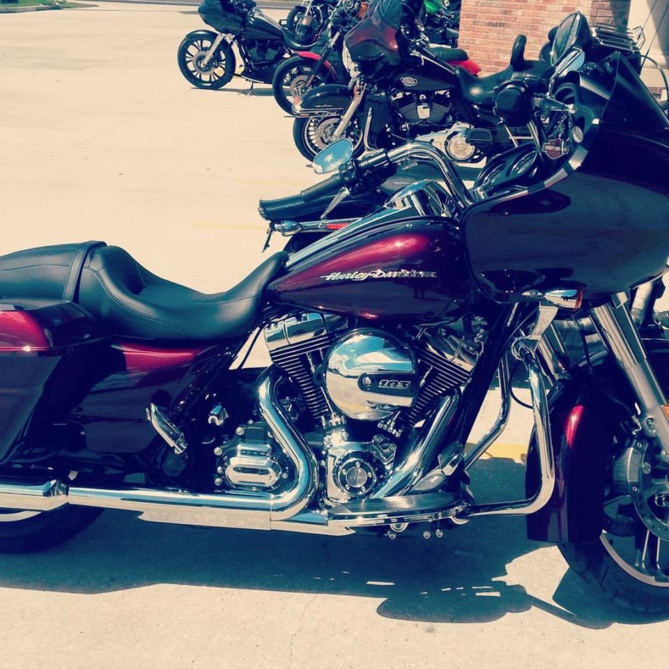 Dark red Harley-Davidson touring motorcycle with chrome engine and fairing, parked in a row with other motorcycles.