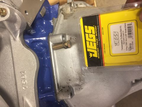 1982 Ford Bronco - A close-up view shows a JEGS Transmission To Block Bolt Kit, part number 32512, next to a silver-colored metal component with blue paint. T…