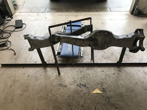 1996 Ford Bronco - Front axle assembly mounted on a stand for modification or repair.