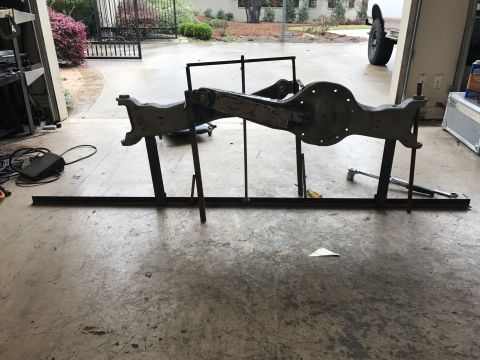 1996 Ford Bronco - A disassembled Ford Bronco front axle assembly is mounted on a stand in a garage setting.