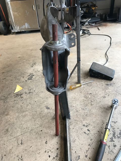 1996 Ford Bronco - A disassembled suspension component is shown on a workshop floor with a screwdriver and torque wrench nearby.