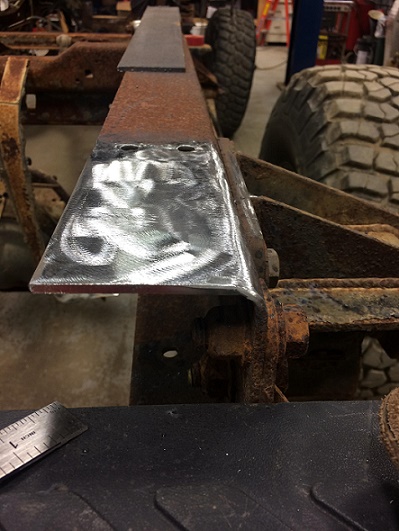 1993 Ford Bronco - Welding a new bracket onto a vehicle's frame during a repair or modification.