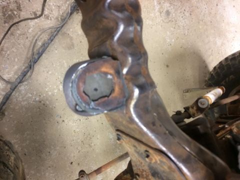 1993 Ford Bronco - Close-up of a rusted metal frame part with a bushing, likely from a vehicle undergoing repair.