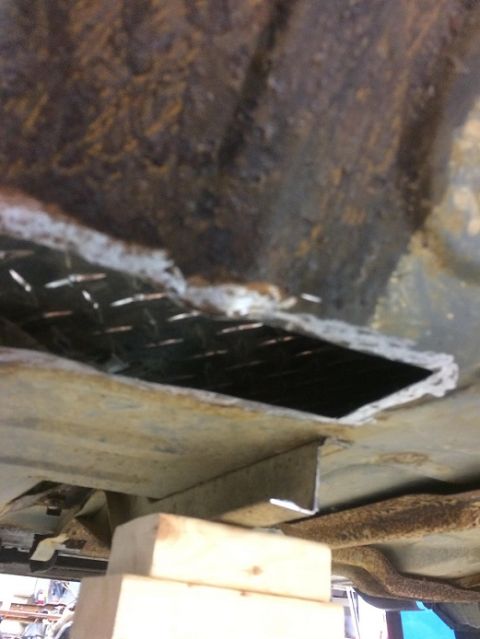 1993 Ford Bronco - This photo shows modifications being made to the frame of a vehicle, with a section cut out and the vehicle supported by blocks.