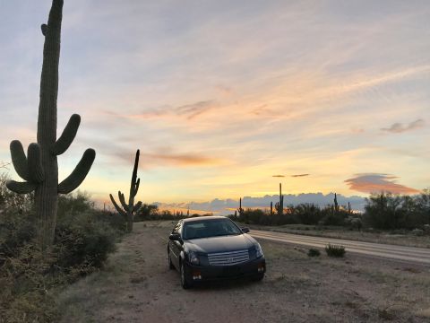 2007 Cadillac CTS - Cadillac CTS parked on a dirt road in the desert at sunset with saguaro cacti.
