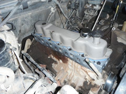 1995 Ford F-150 - Close-up view of a Ford engine during a valve cover gasket replacement, highlighting the engine block and associated components.