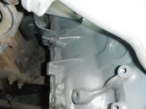 1995 Ford F-150 - A close-up view of a gray-painted engine component, possibly a transmission housing, with visible bolts and mounting brackets. The surround…