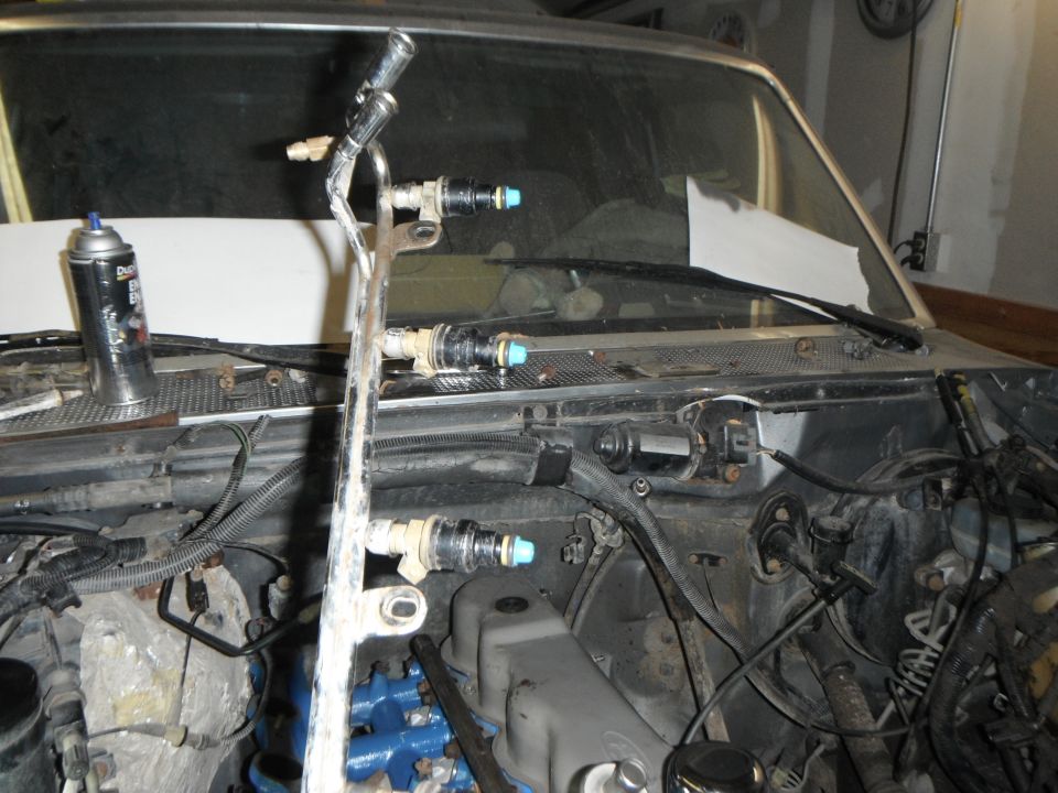 1995 Ford F-150 engine bay with fuel rail, injectors, and spray cleaner can.
