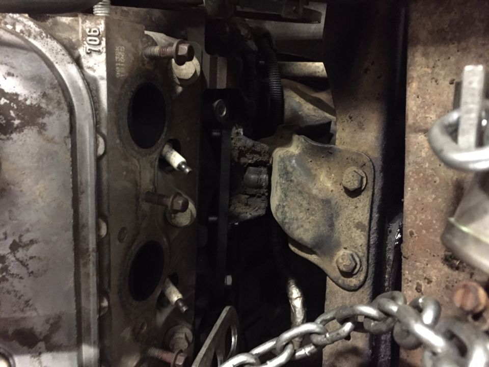 Close-up of a dirty V8 engine cylinder head with spark plugs.
