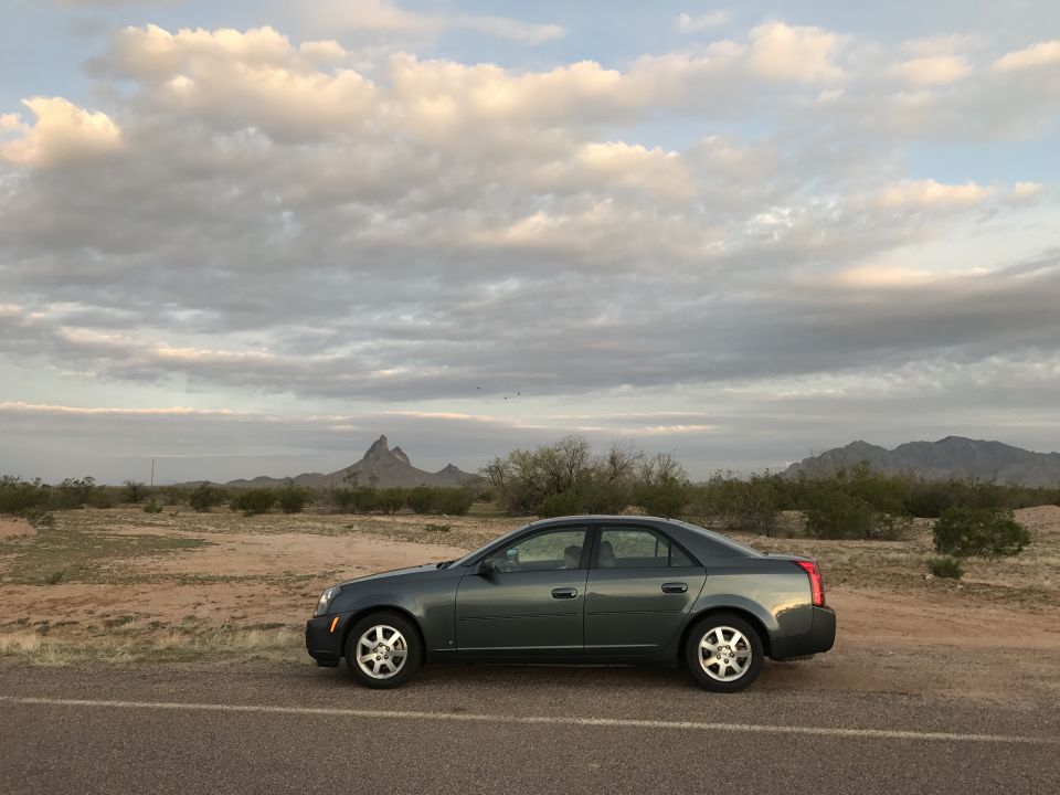 2007 Cadillac CTS sedan parked on the side of a road in a desert landscape.