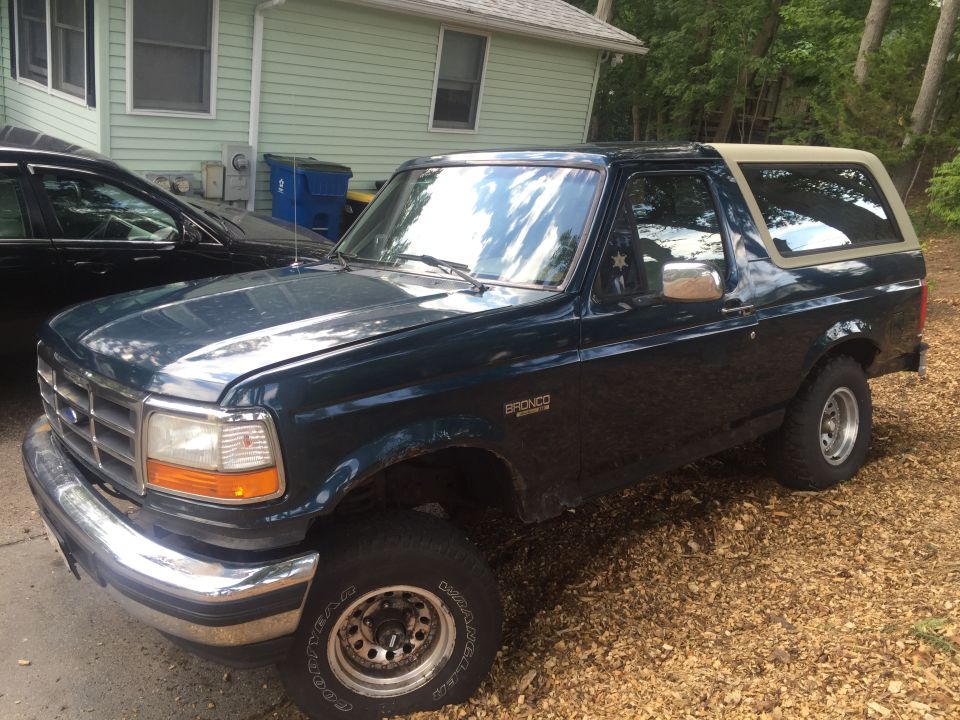 1995 Ford Bronco parked on gravel driveway, front three-quarter view.