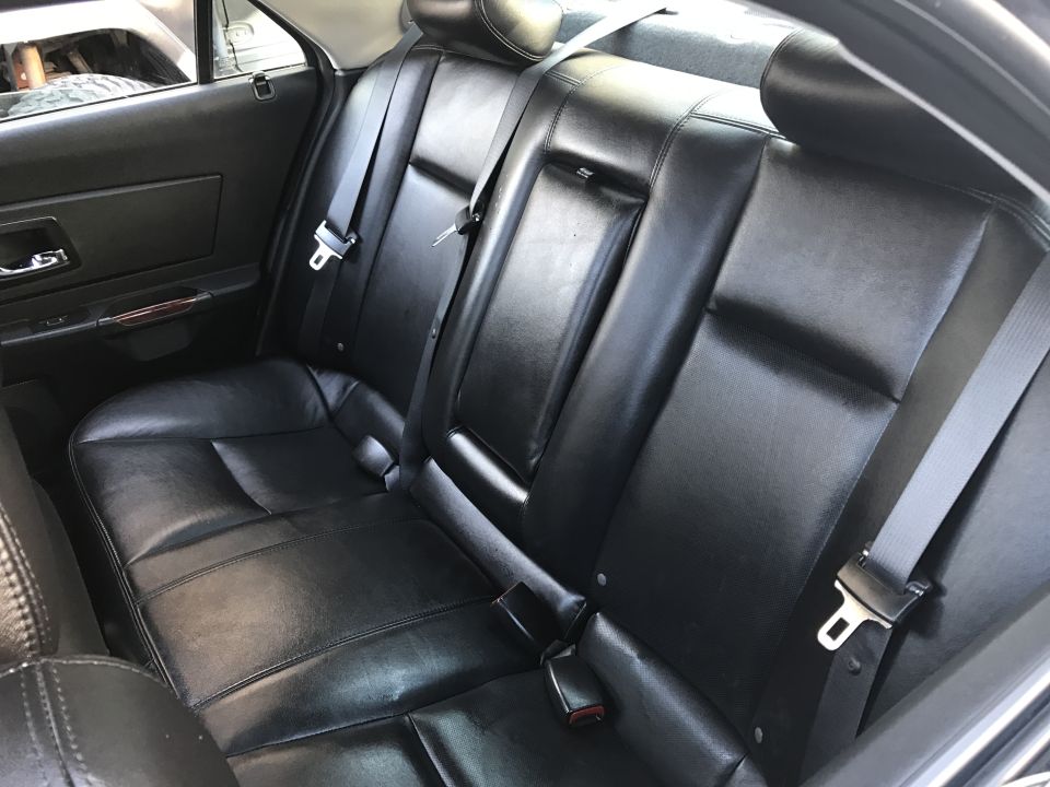 Black leather rear car seats with seat belts.