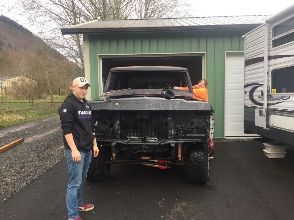 1973 Ford F-Series truck with front end removed, two people visible