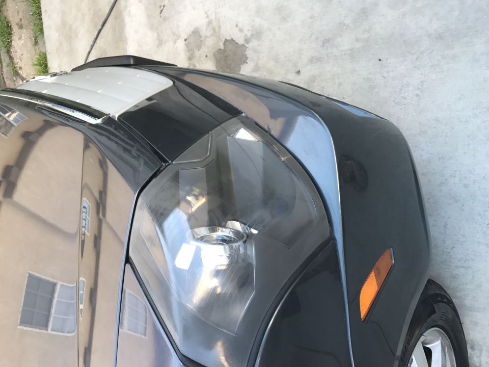 Dark gray car's front fender and headlight assembly with orange side marker