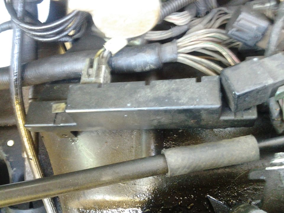 Close-up of a black automotive electrical component with wiring harnesses.