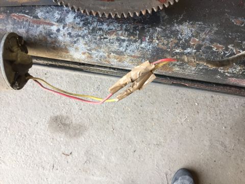 1979 Ford Bronco - A close-up shows electrical wiring taped together and connected to a component, possibly from a vehicle. The wiring consists of red and yel…