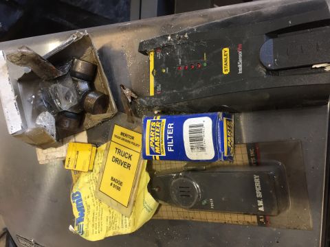 1979 Ford Bronco - A collection of automotive parts and documents are laid out on a metallic surface. Visible items include a Stanley IntelliSensor Pro, a Par…