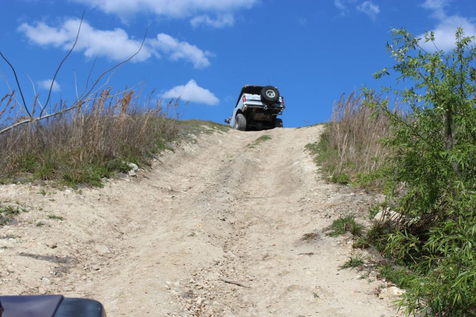 White SUV climbing a steep dirt hill.