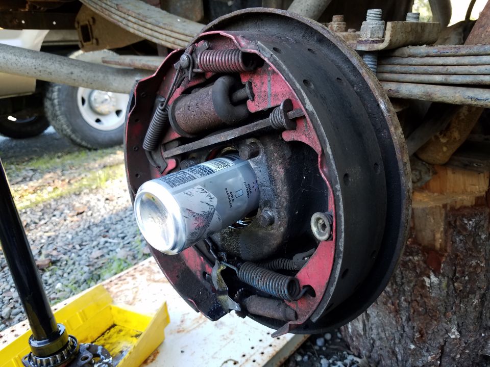 Close-up of a vehicle's drum brake assembly with a silver can inside.