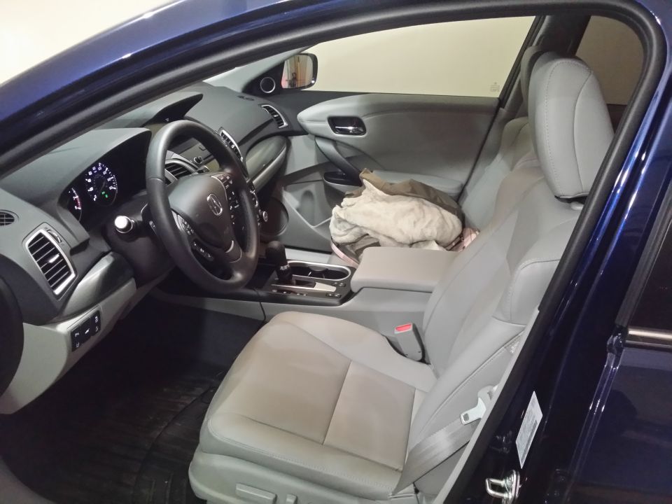 Interior view of a dark blue Acura MDX showing the driver's seat, steering wheel, and dashboard.