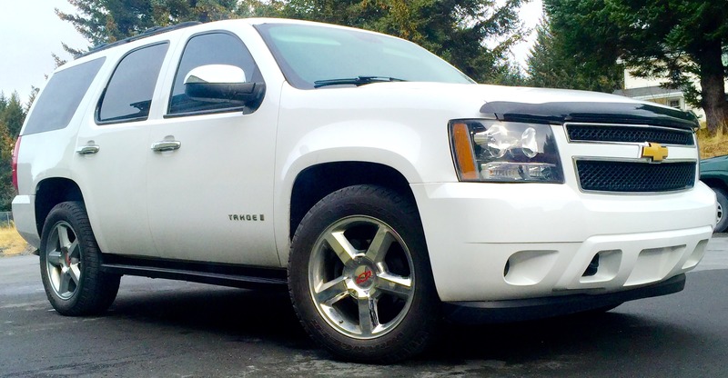 White Chevrolet Tahoe SUV parked outdoors, front 3/4 view