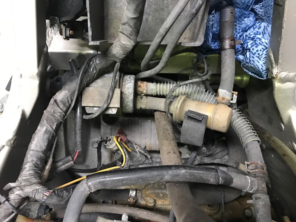 Close-up of motorcycle engine bay with hoses and wiring