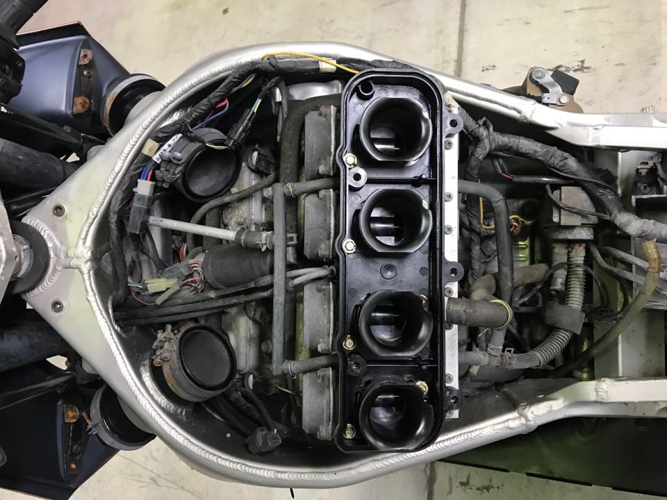 Motorcycle engine bay with fuel injectors and wiring visible