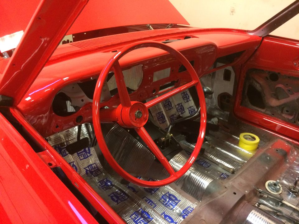 Interior of a red 1964 Ford Fairlane with sound deadening on the floor and dashboard.
