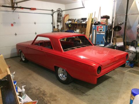 1964 Ford Fairlane - A red coupe sits in a cluttered garage, appearing to be undergoing restoration.
