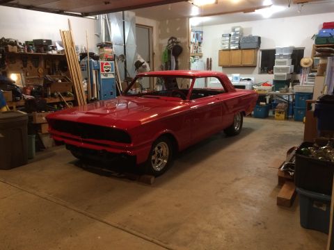 1964 Ford Fairlane - A red 1964 Ford Fairlane coupe is parked in a cluttered garage.