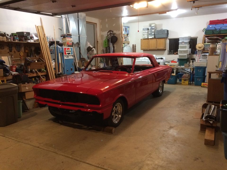 Red 1964 Ford Fairlane coupe in garage, front 3/4 view