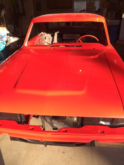 1964 Ford Fairlane - Front view of a red 1964 Ford Fairlane body undergoing restoration in a garage.