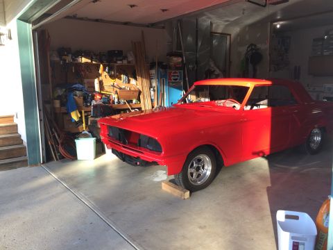 1964 Ford Fairlane - A red 1964 Ford Fairlane coupe is parked in a garage with its front end partially disassembled.