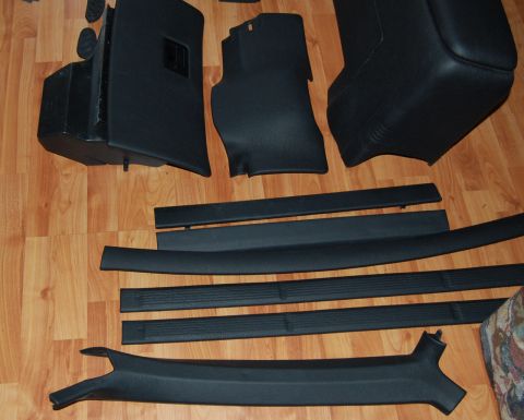 1985 Mercury Grand Marquis - Various interior trim pieces, including door sill plates and pillar covers, are displayed on a wood floor.