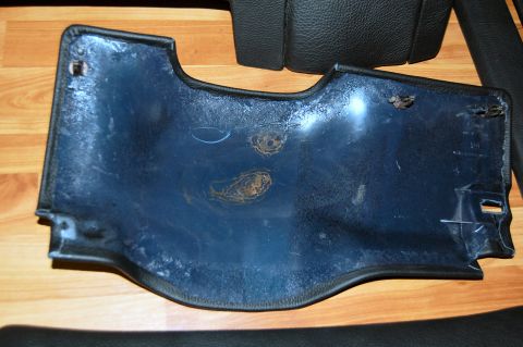 1985 Mercury Grand Marquis - A dark blue plastic interior car panel with visible rust spots is shown on a wooden floor.