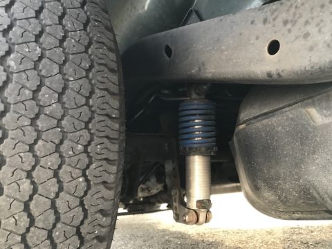 1968 Ford Mustang - Photograph of a vehicle suspension shock and tire, not a technical document.