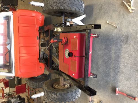 1984 Ford Bronco - A red pickup truck bed and chassis are shown from an overhead perspective, with a large red fuel tank mounted beneath the bed. Tools and ve…