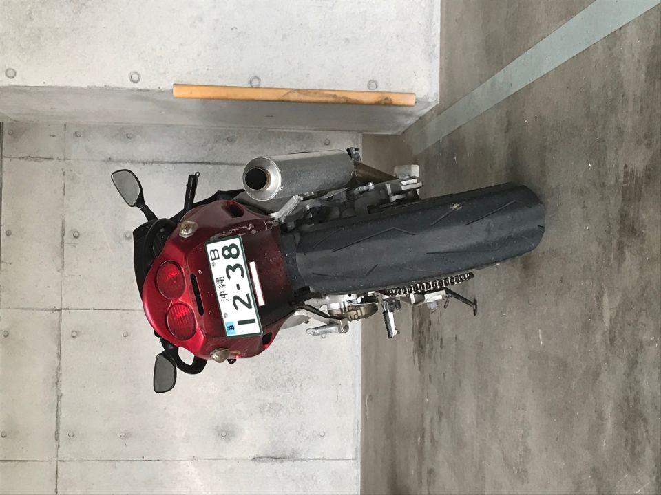 Red 1998 Kawasaki Ninja R motorcycle, rear view, showing license plate "12-38" and silver exhaust.