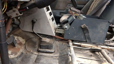 1990 Ford Bronco - Photo of a gutted truck interior with shifter and wiring, not a technical document.