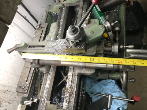 1996 Ford Bronco - A metal shaft is being worked on a lathe, indicated by metal shavings and measuring tape.